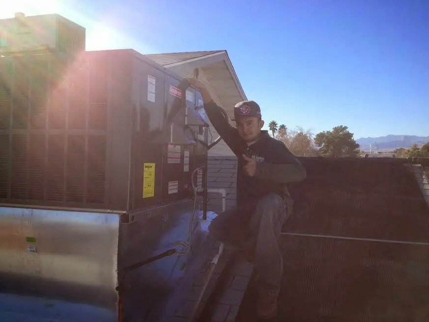 HVAC technician performing AC Tune-Up on a rooftop unit in Winthrop